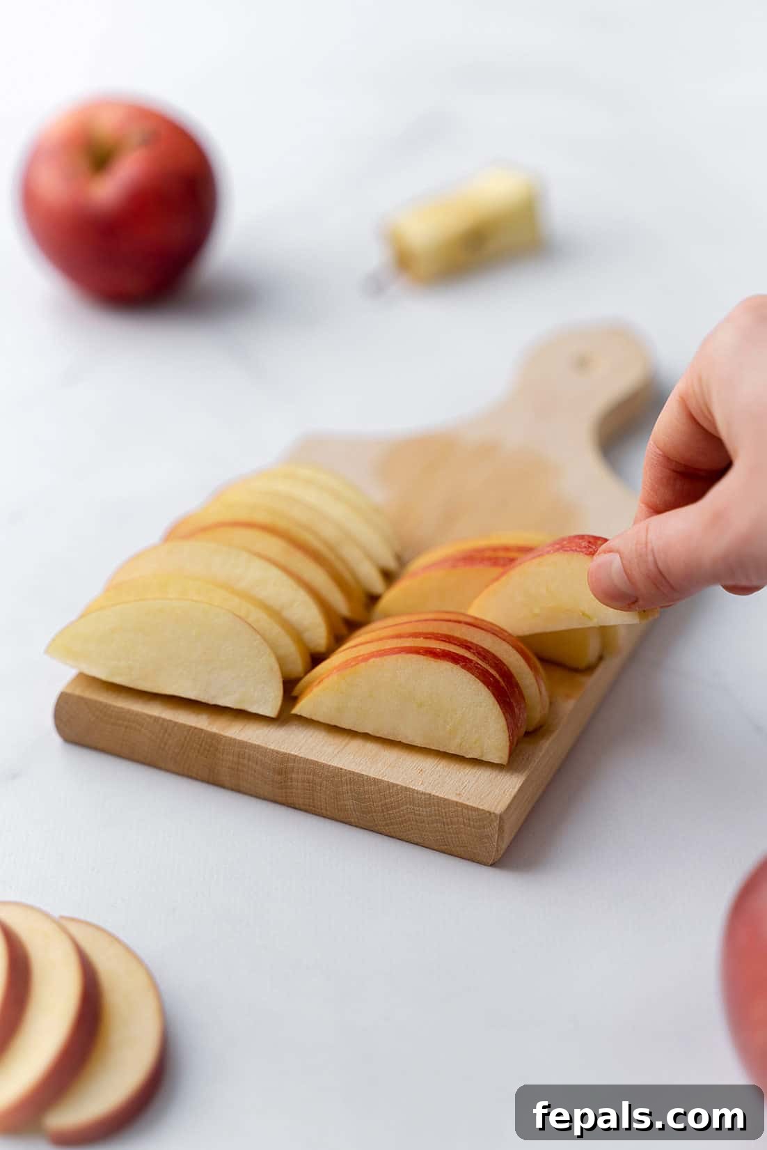 How to Cut an Apple for Any Occasion apple slices on wooden cutting board, beautifully arranged and ready for a meal