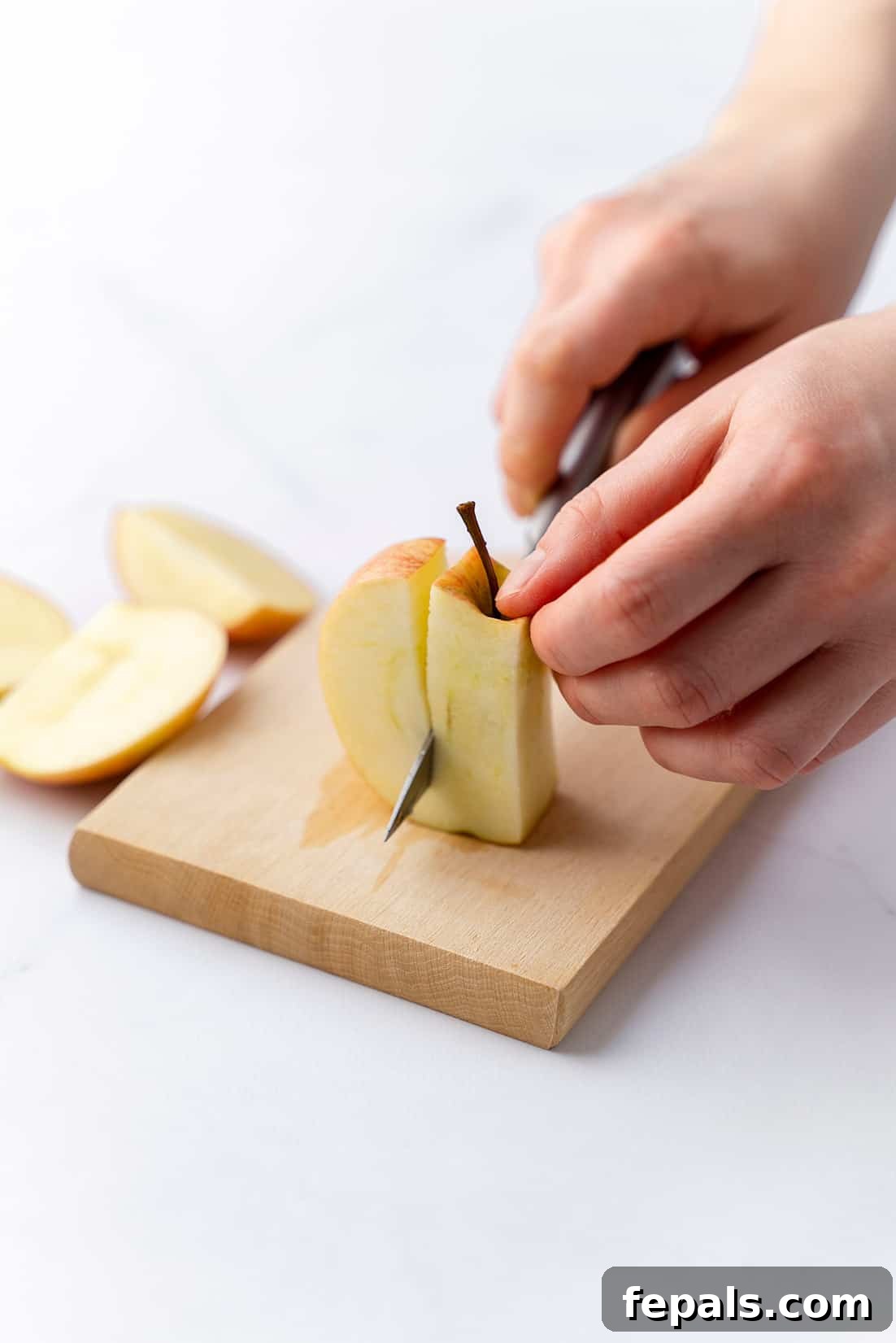 How to Cut and Core an Apple Efficiently cutting the apple pieces off the core of an apple with a knife, highlighting precision