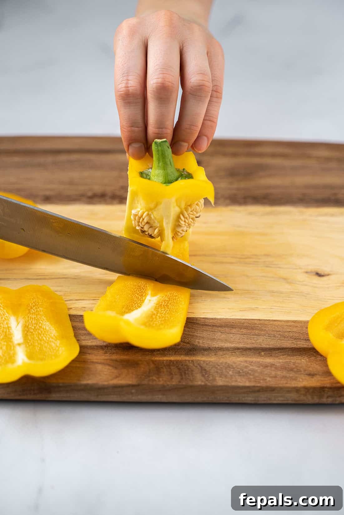 Master Bell Pepper Cutting Three Ways 14 The third side of the bell pepper being sliced away, leaving the core and remaining flesh.