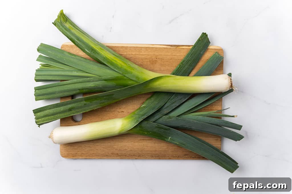 Mastering Leek Slicing 3 Leeks on a cutting board.