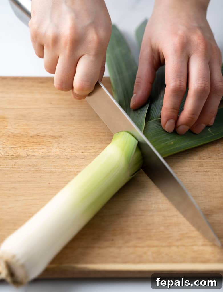 Mastering Leek Slicing 4 hand slicing the leek in half with a knife