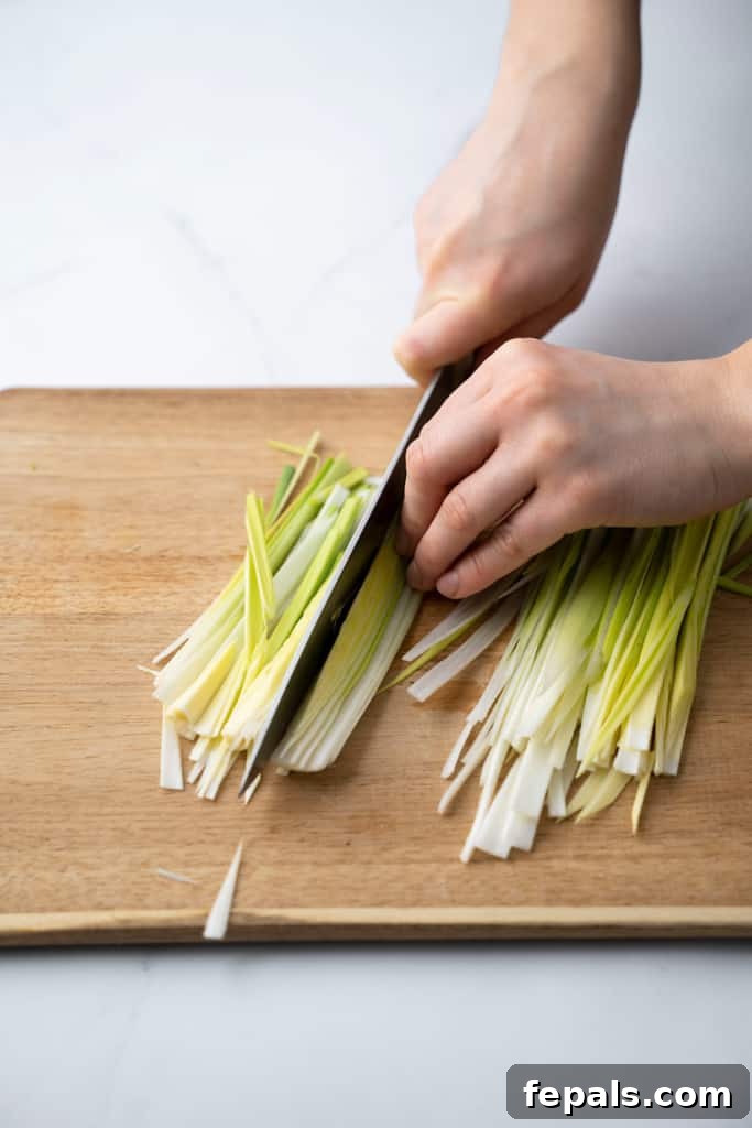 Mastering Leek Slicing 7 Leeks being sliced on a cutting board.