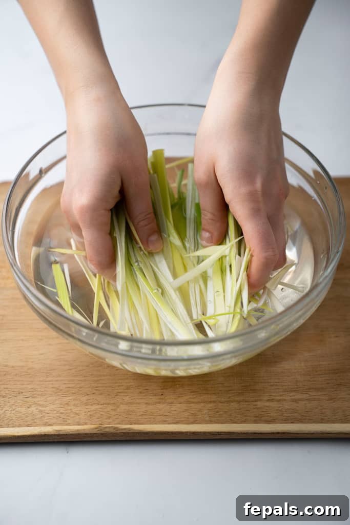 Mastering Leek Slicing 11 Sliced leeks being washed in a bowl.