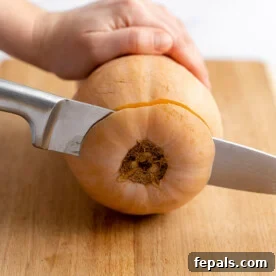 side shot of how knife slicing the bottom end of the butternut squash