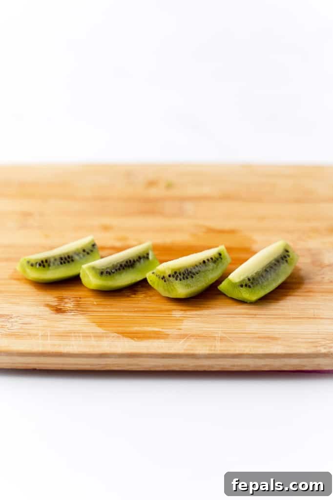 Effortless Kiwi Cutting Techniques 12 Kiwi wedges on a cutting board.