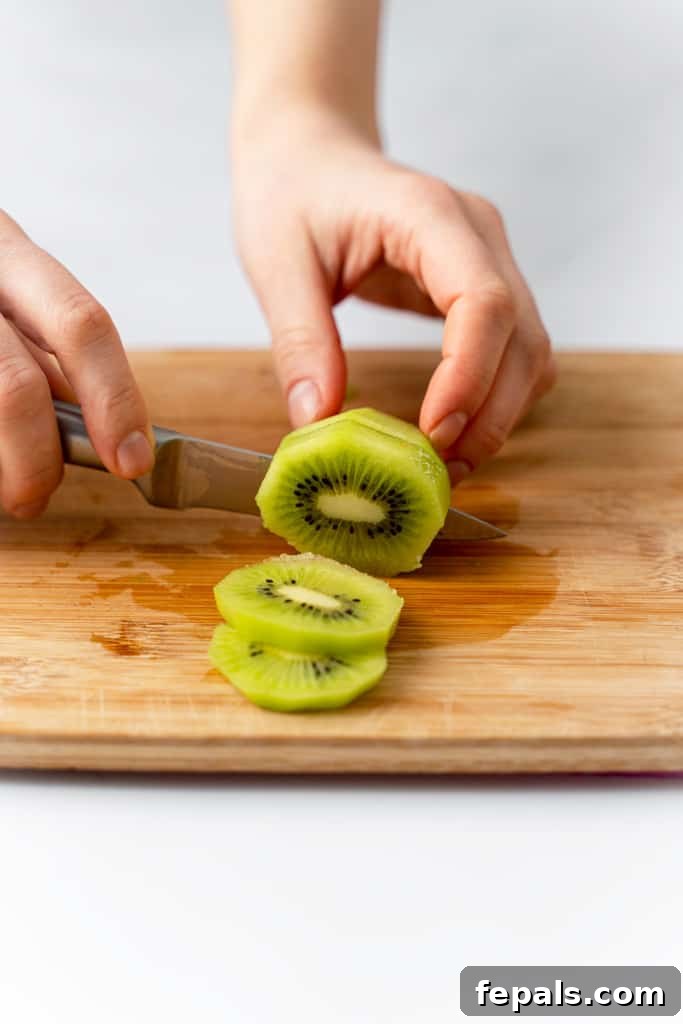 Effortless Kiwi Cutting Techniques 8 A kiwi being cut into round slices.