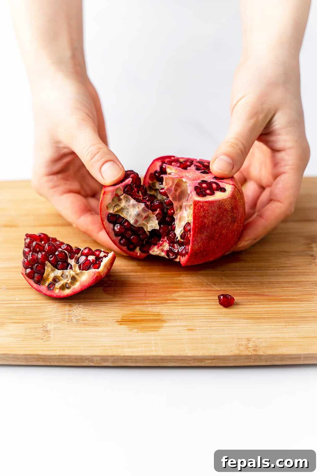 How to Cut a Pomegranate A single ripe pomegranate, partially opened to reveal its glistening arils.