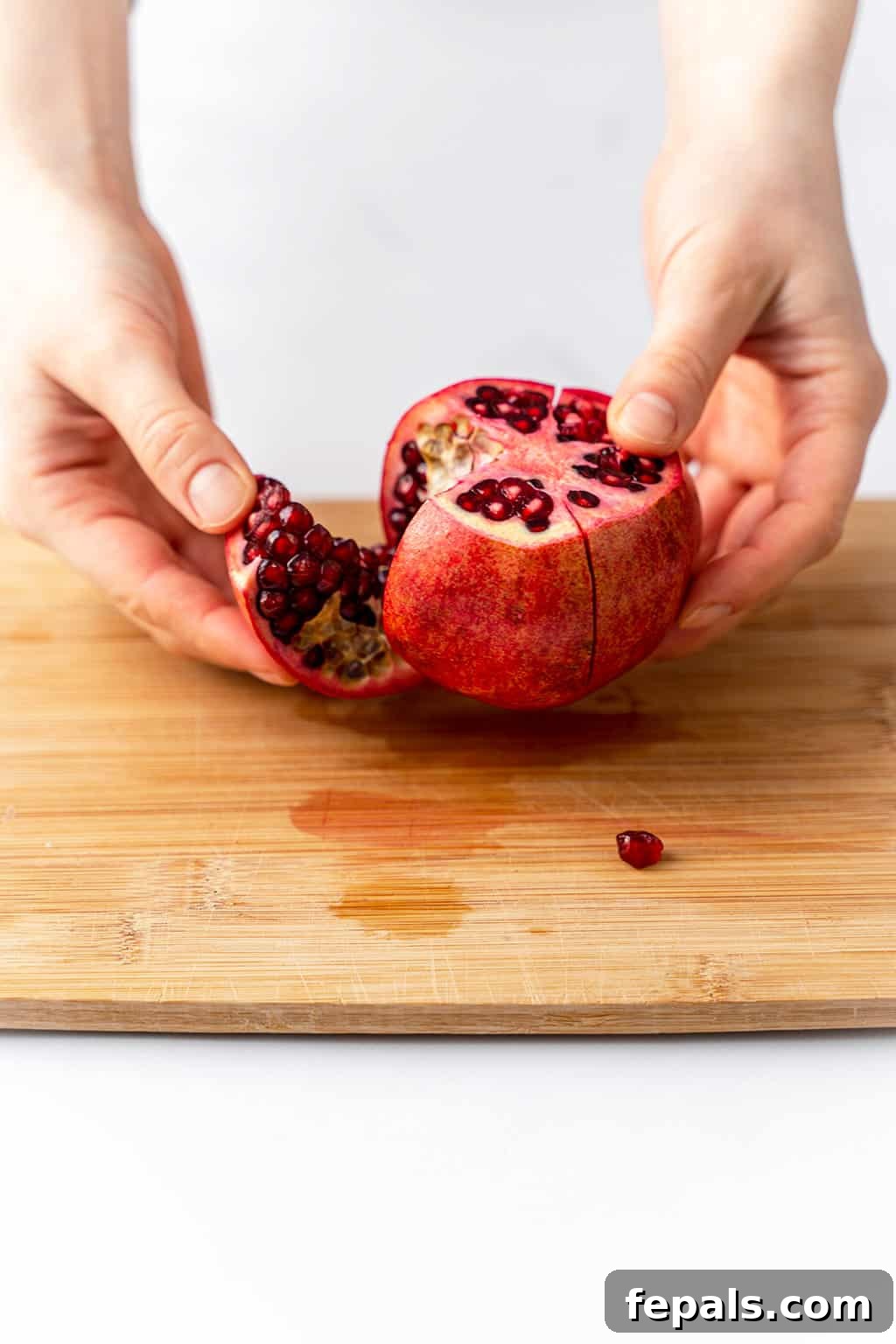 How to Cut a Pomegranate A pomegranate neatly sliced into four segments, ready to be opened.