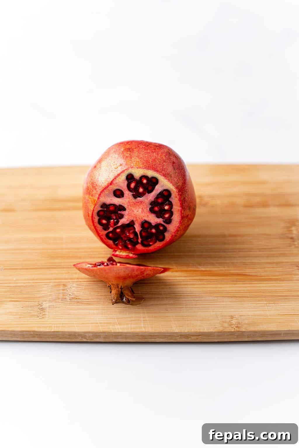 How to Cut a Pomegranate One end of the pomegranate neatly sliced off, revealing the internal structure.