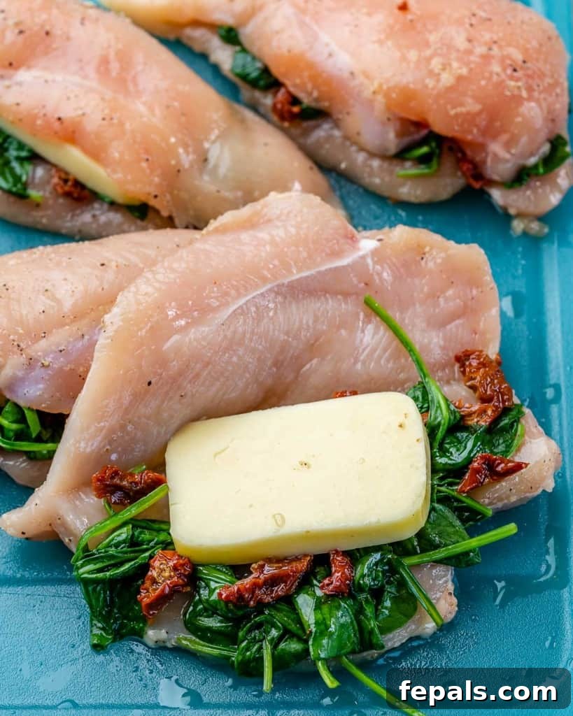 Tuscan Countryside Stuffed Chicken 5 Uncooked chicken breasts, neatly stuffed with mozzarella cheese, sun-dried tomatoes, and spinach, sealed with toothpicks, ready for searing.