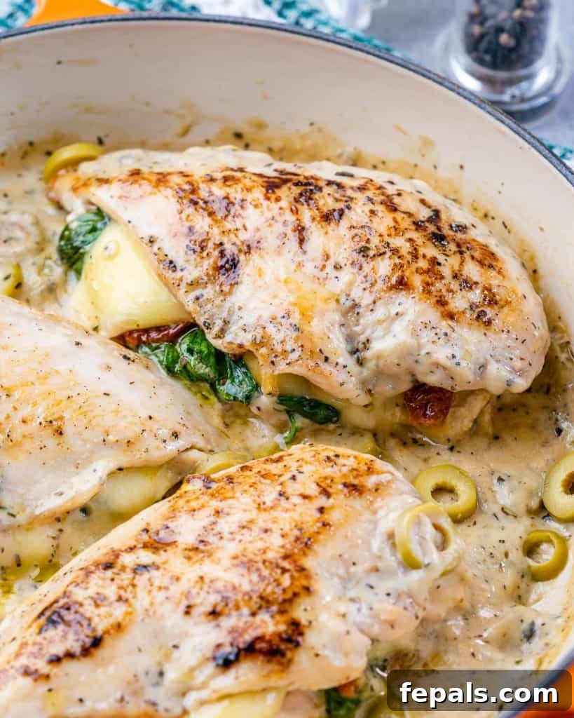 Tuscan Countryside Stuffed Chicken 8 Side shot of succulent Tuscan stuffed chicken breast bathed in its creamy sauce within an orange skillet.