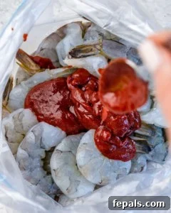 Smoky BBQ Shrimp 14 bbq sauce being poured over shrimp in ziplock bag