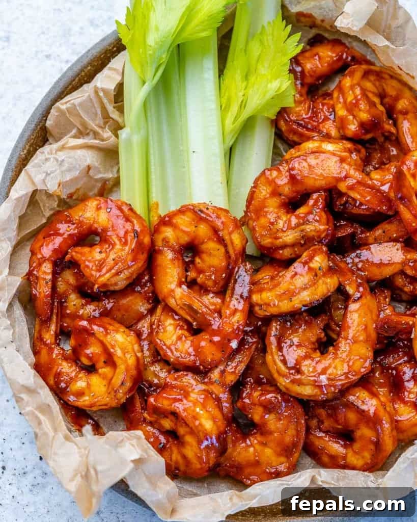 Smoky BBQ Shrimp 9 top view shrimp in a plate lined up with brown parchment paper