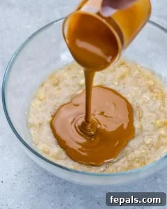 Chewy Raisin Oat Delights 13 Peanut butter being poured over mashed bananas in a bowl.