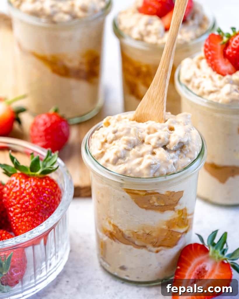 Creamy Peanut Butter Protein Overnight Oats 8 spoon in a jar containing overnight oats with a side of fresh strawberries