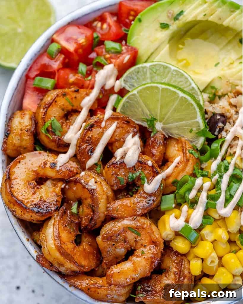top view of a shrimp burrito bowl with corn, avocado and tomatoes