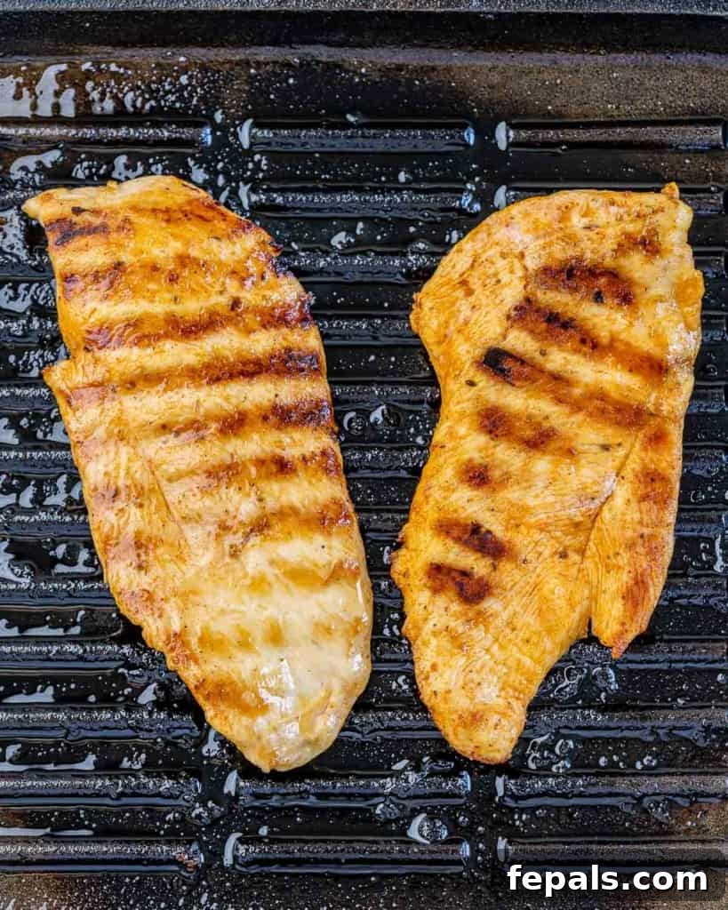 two grilled chicken breast on a grill pan