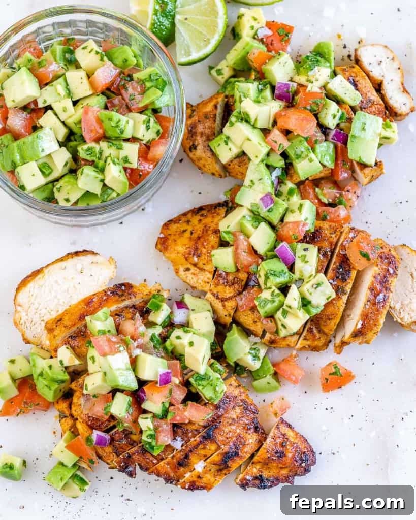 Smoky Grilled Chicken with Zesty Avocado Salsa 3 Top-down view of a beautifully arranged plate with sliced grilled chicken breast, generously topped with fresh avocado salsa, garnished with cilantro.