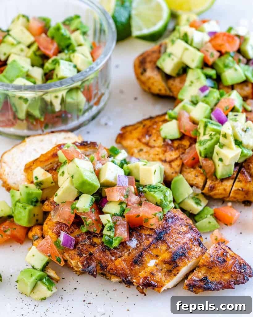 Smoky Grilled Chicken with Zesty Avocado Salsa 9 Side shot of a perfectly cooked and sliced grilled chicken breast, showcasing its juicy interior and golden-brown, charred exterior.