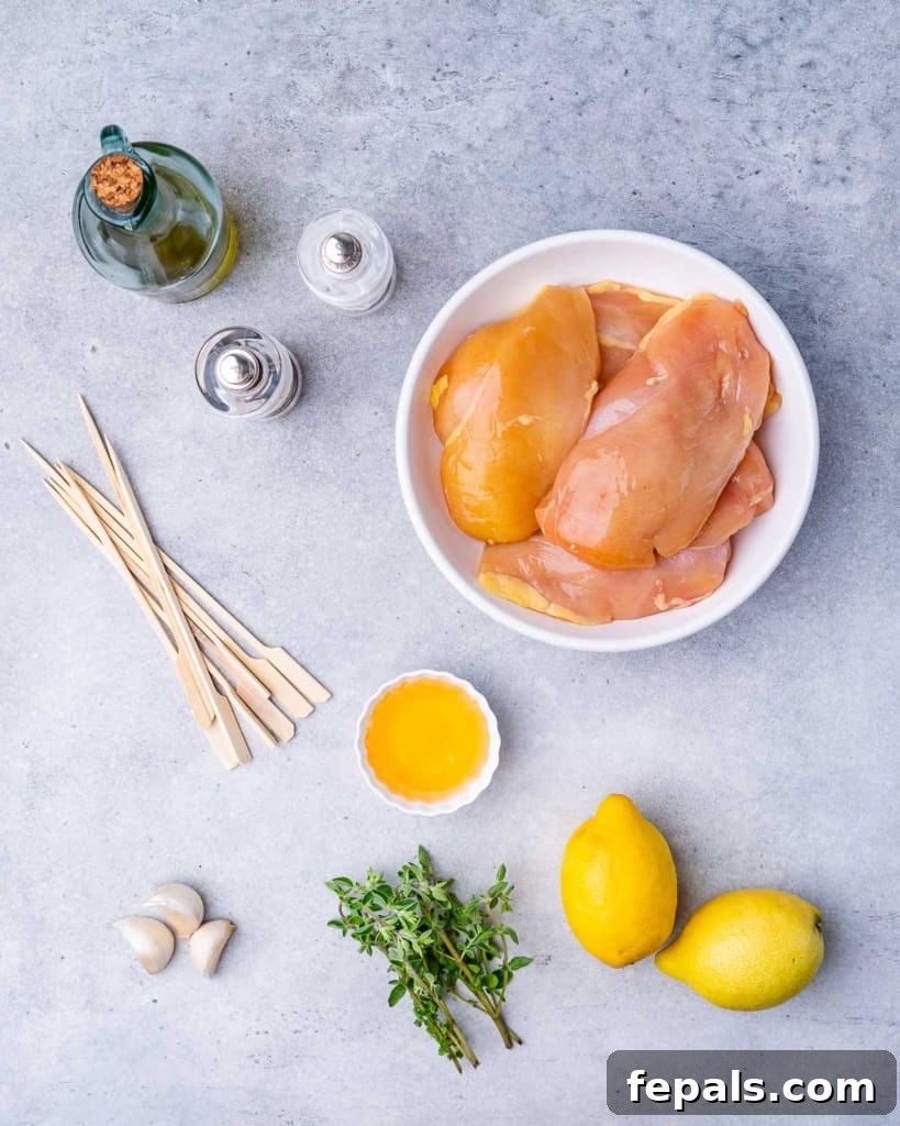 fresh ingredients for lemon chicken skewers including lemons, herbs, and chicken