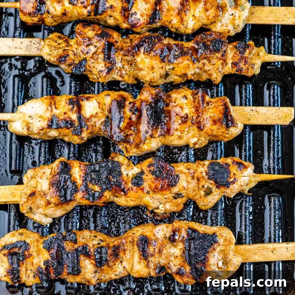 grilled lemon chicken skewers on grill with marinade sizzling