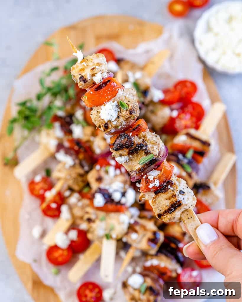 hand holding chicken skewers