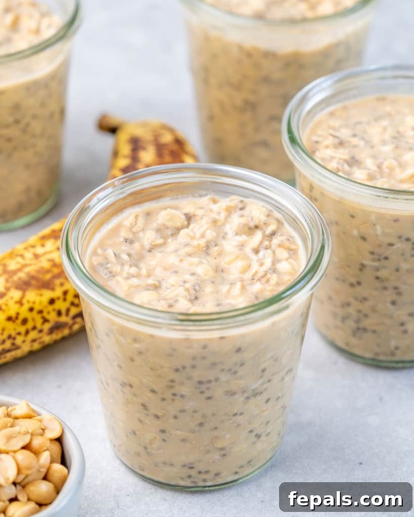 Three glass jars filled with peanut butter banana overnight oats, garnished with banana slices and peanuts.