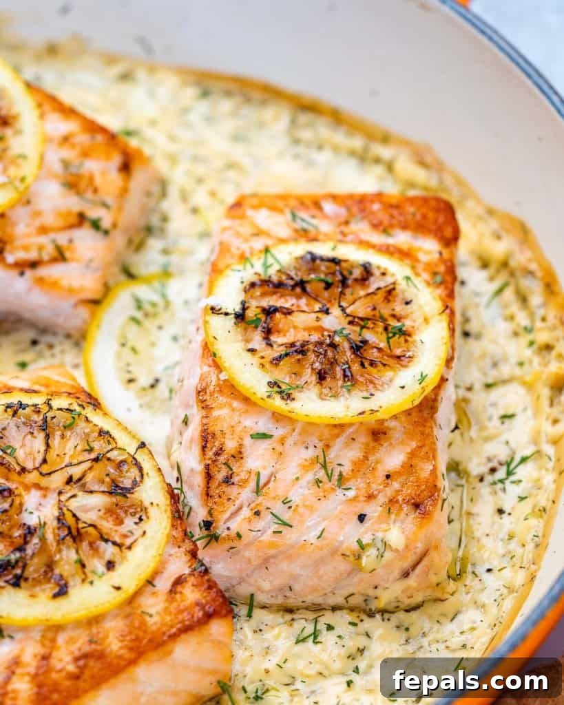 Silky Lemon Cream Salmon 3 side shot of salmon filets in a creamy lemon sauce topped with slices of roasted lemons