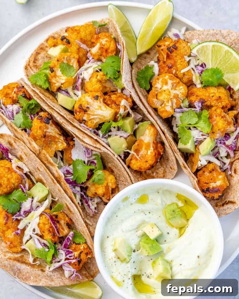 Top-down view of vibrant Parmesan Roasted Cauliflower Tacos with a creamy sauce on the side, ready to be enjoyed.
