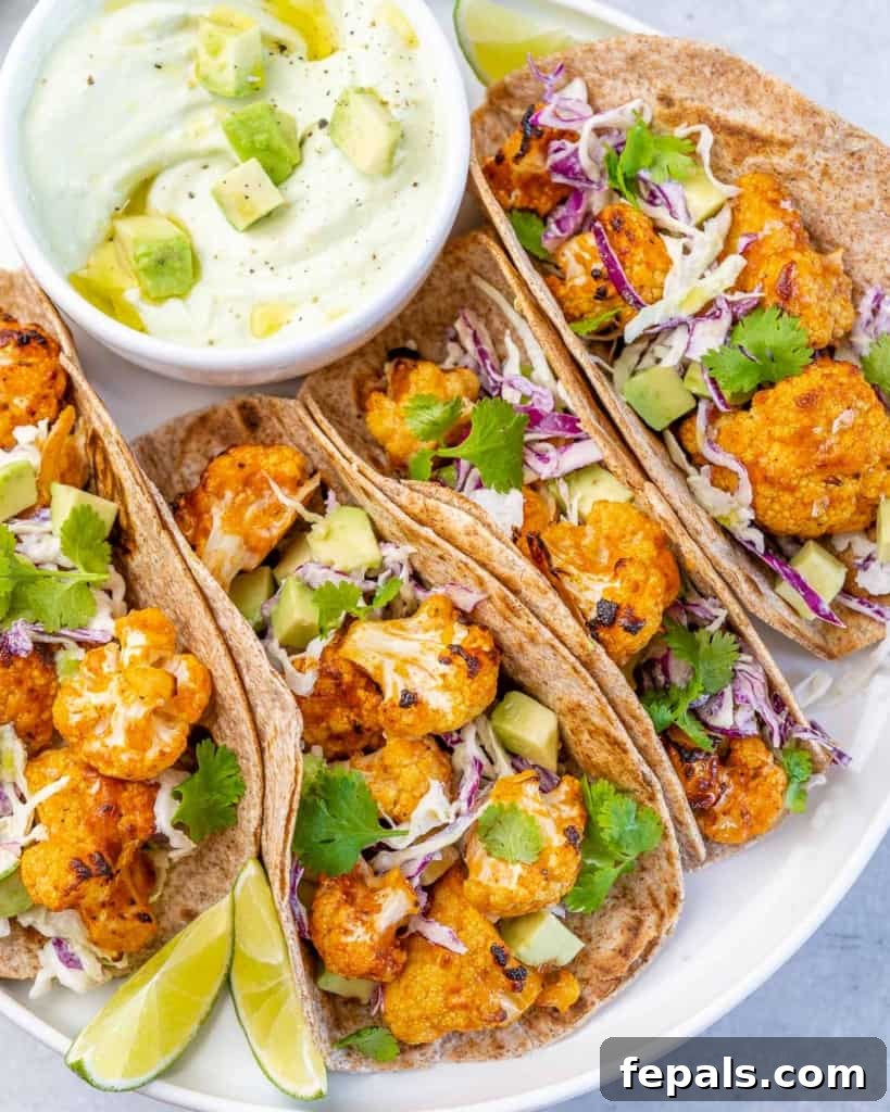 A perfectly composed side shot of a single cauliflower taco, showcasing its vibrant layers and textures, resting on a white plate.