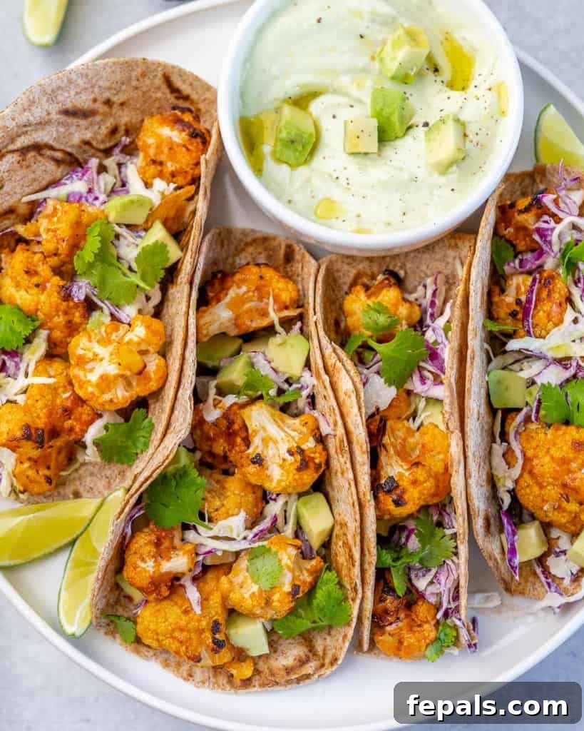 Side view of two appetizing veggie tacos on a clean white plate, artfully arranged for a tempting presentation.