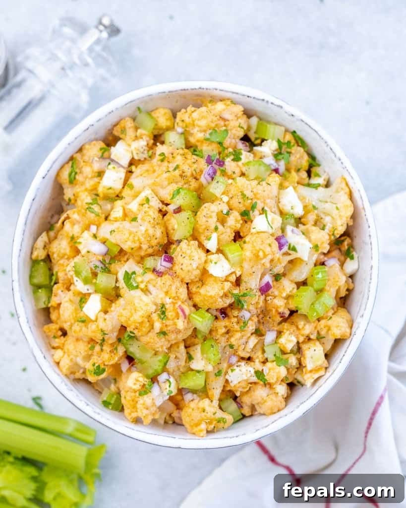 Cauliflower Mock Potato Salad 2 Cauliflower potato salad served in a white bowl, garnished with fresh herbs, ready to be enjoyed as a keto-friendly meal.