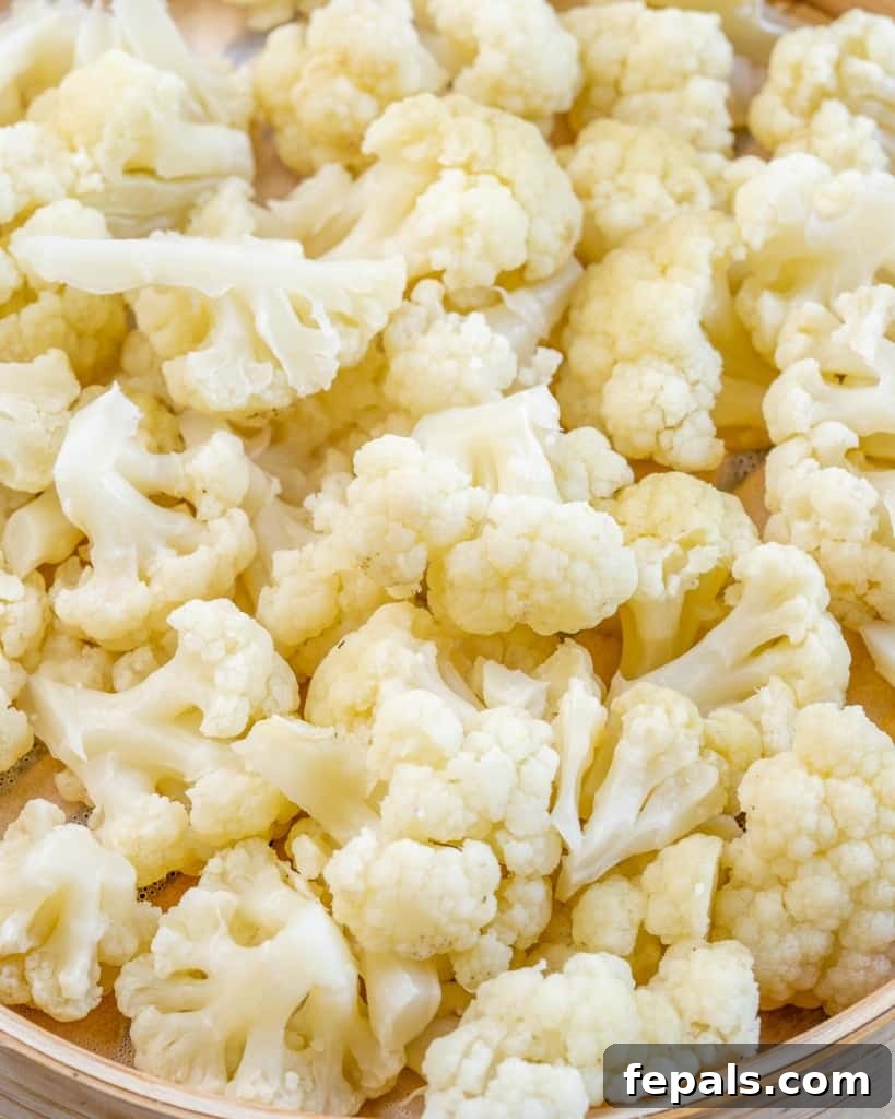 Cauliflower Mock Potato Salad 5 Steamed cauliflower florets in a bamboo steamer basket, showing the preparation step for keto potato salad.