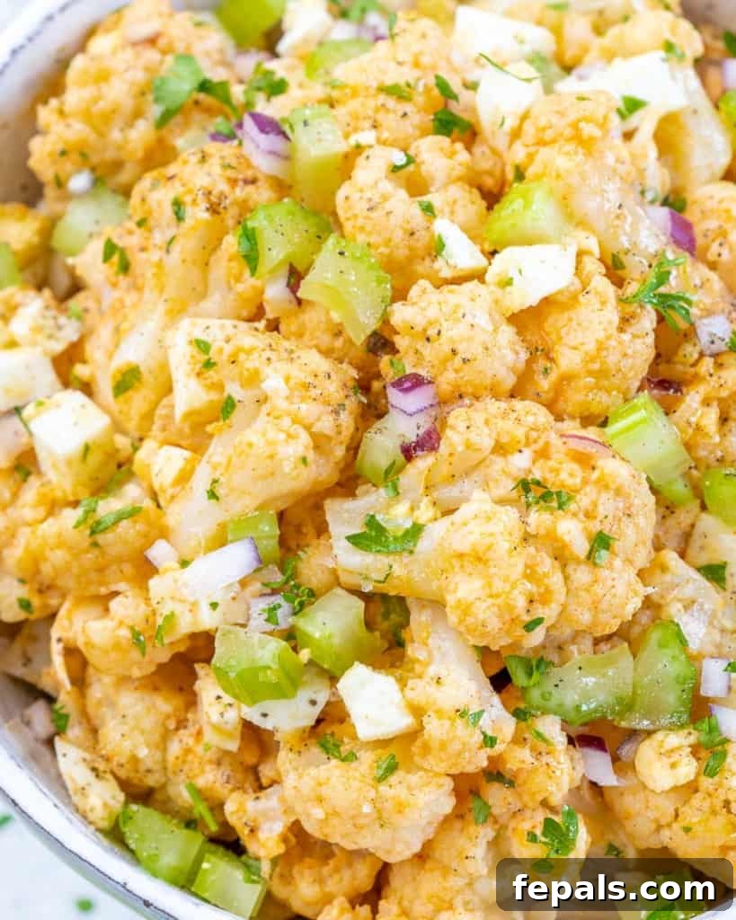 Cauliflower Mock Potato Salad 8 Close-up view of a serving of keto cauliflower potato salad, showcasing its creamy texture and fresh ingredients.