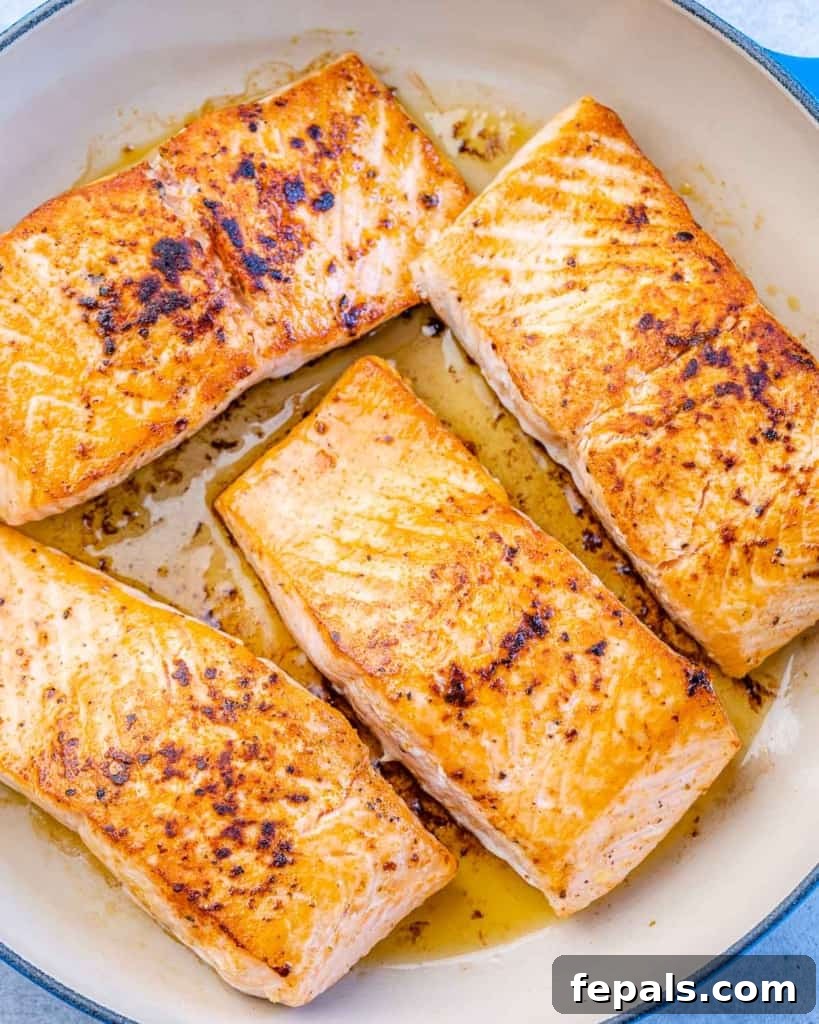 Perfectly cooked salmon fillets in a pan, ready for the glaze.