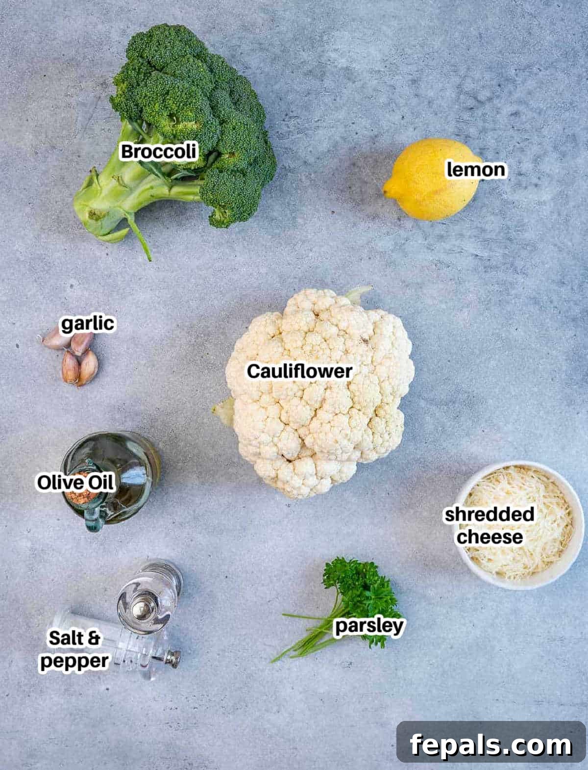 Ingredients to make roasted broccoli and cauliflower including fresh broccoli, cauliflower, lemon, garlic, and parmesan.