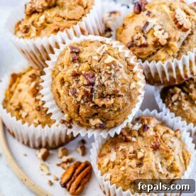 side shot of apple muffins stacked over each other on a plate