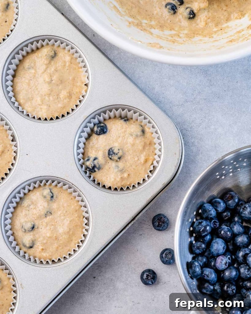 Muffin batter filled into individual muffin tins, ready for baking.