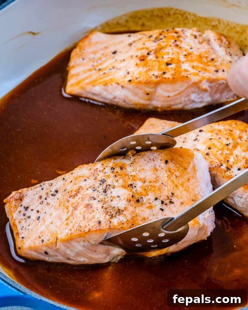 Sweet and Sticky Pan Seared Salmon 6 salmon filet being placed in honey glaze sauce