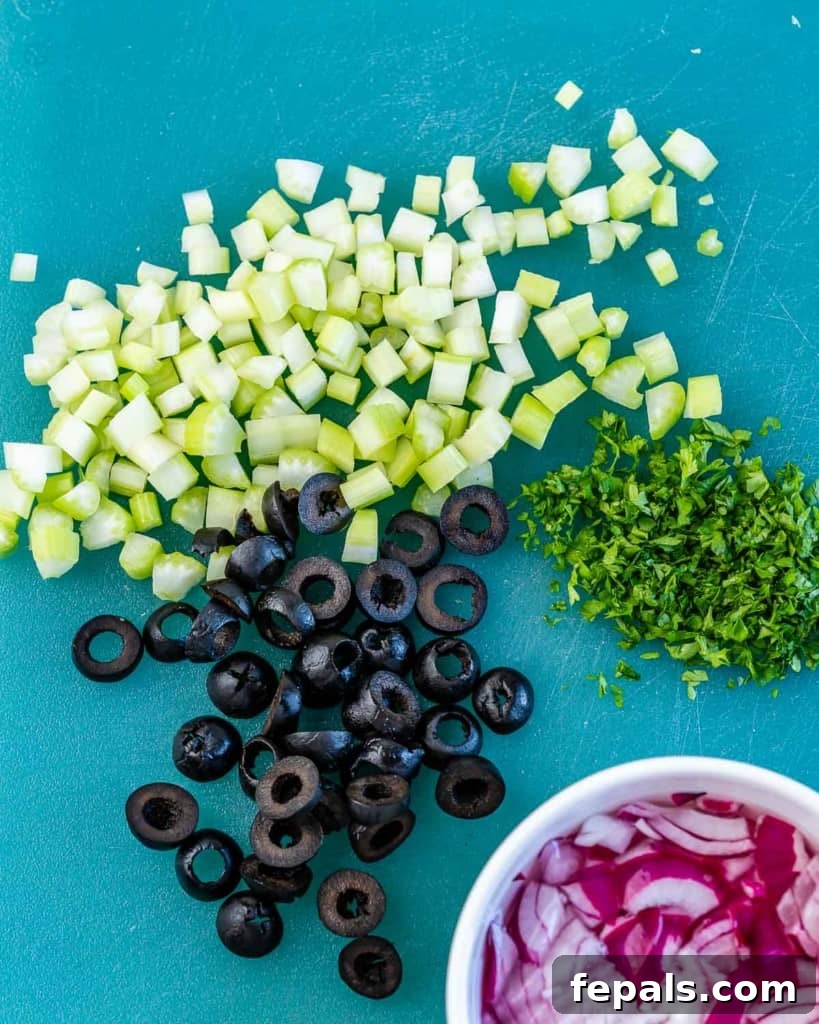Wholesome White Bean Tuna Medley 5 chopped olives, parsley, celery, and onions on a chopping board
