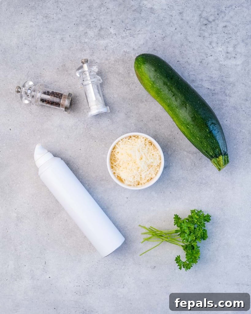 Crispy Air Fryer Zucchini Bites 4 zucchini, parmesan, salt and pepper, cooking spray, and parsley on a flat surface