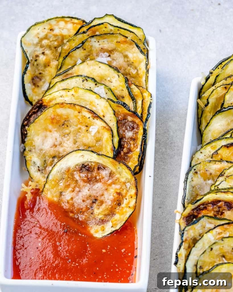 Crispy Air Fryer Zucchini Bites 8 close up image of zucchini chips next to marinara in a white dish
