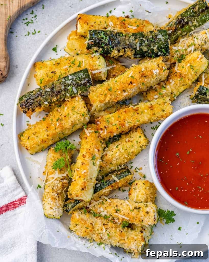Crispy Air Fryer Zucchini Parmesan Fries 3 top view zucchini fries on a white plate with a side of marinara sauce