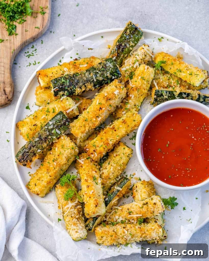 Crispy Air Fryer Zucchini Parmesan Fries 7 top view of zucchini fries on a plate with dipping red sauce