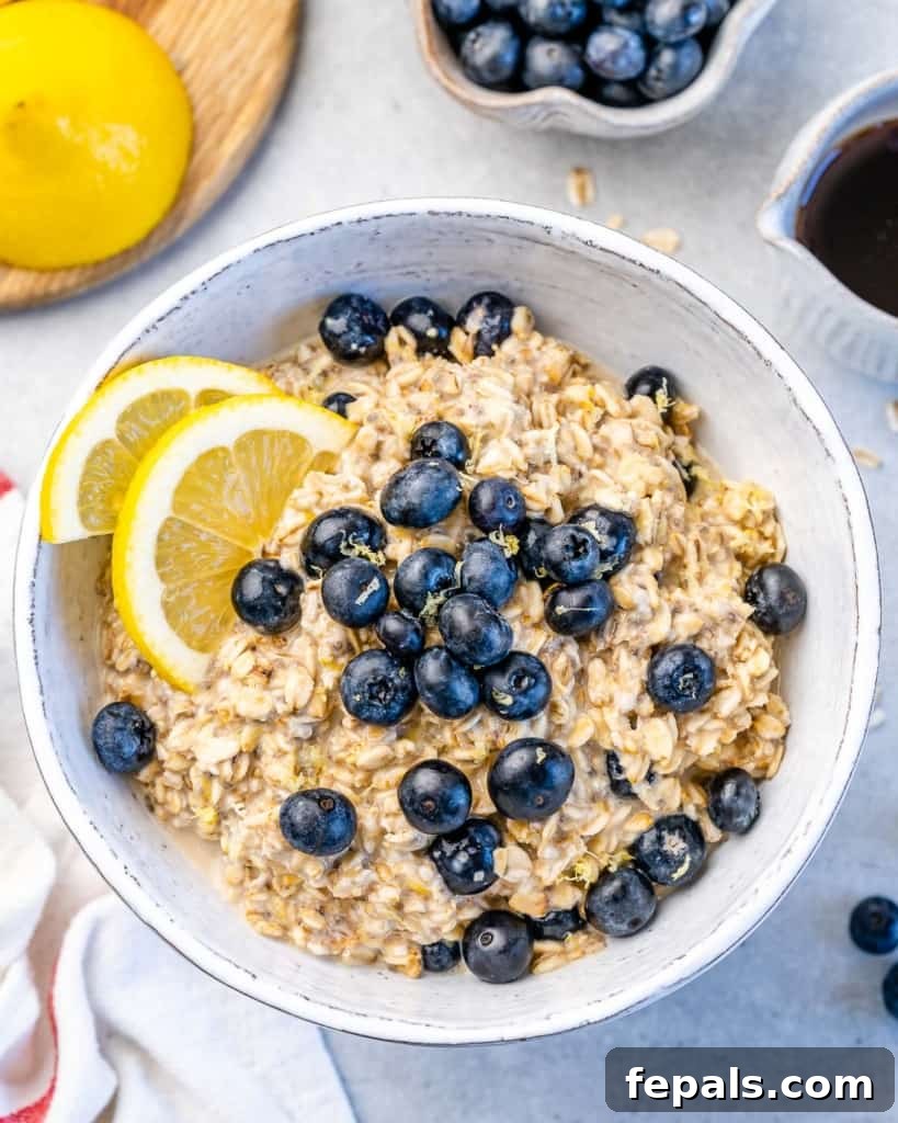 Berry Bliss Overnight Oats 2 A bowl of creamy blueberry overnight oatmeal topped with fresh blueberries and lemon wedges, ready for a healthy breakfast.