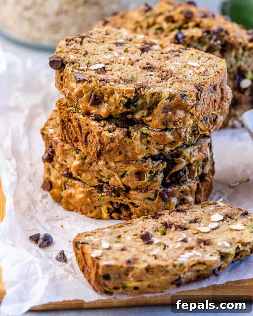Wholesome Chocolate Chunk Zucchini Loaf 2 stacks of zucchini bread slices on a parchment paper