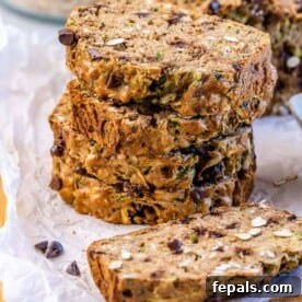 Wholesome Chocolate Chunk Zucchini Loaf 11 stacks of zucchini bread slices on a parchment paper.