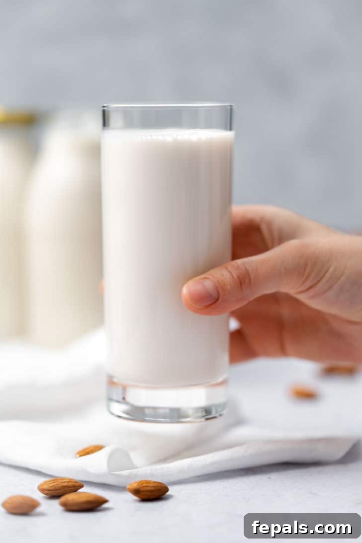 glass of almond milk with hand