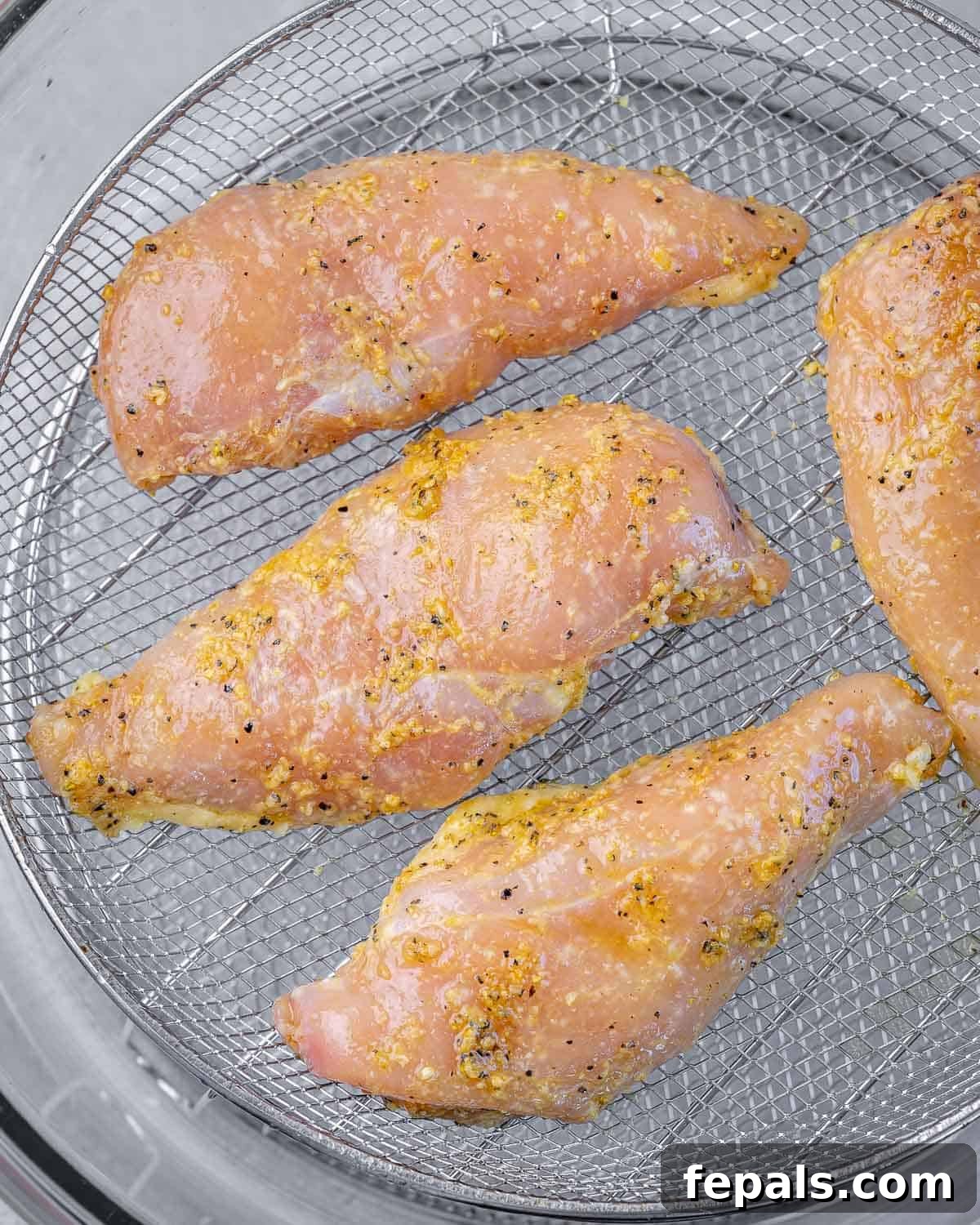marinated chicken breast set on an air frier wired basket