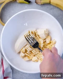 Wholesome Oat Energy Bars 6 mashing bananas with fork in a round bowl.